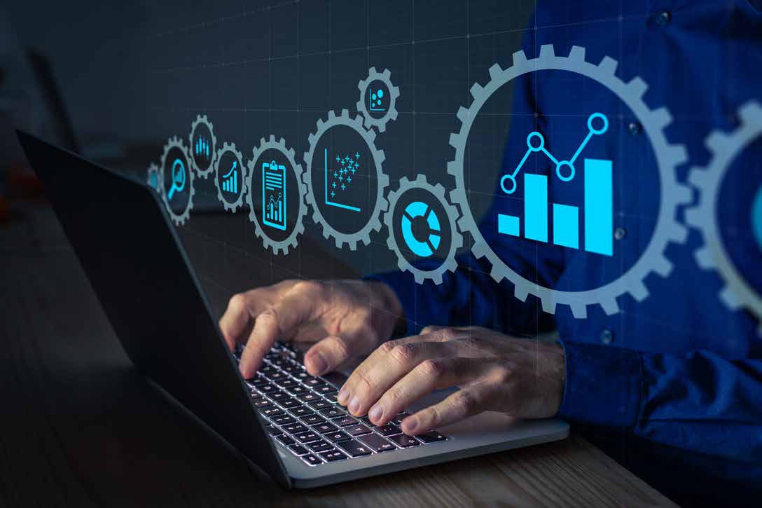 Hands typing on a laptop with logistics analytics and dashboard icons overlaid